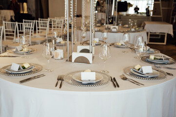 A very beautiful festive table with candles, plates and glasses. Cool room decor