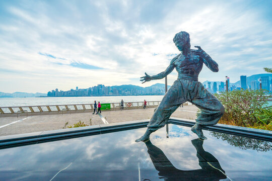 Bruce Lee statue in Avenue of Stars. In the distance is Victoria Harbour. Located in the Avenue of Stars, Hong Kong.