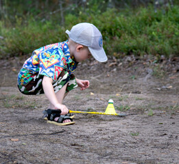 A boy with a racket and a shuttlecock on a forest path. Family Outdoor Vacation Concept