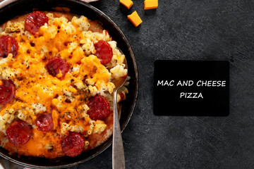 Trendy hybrid food. Mac and cheese pizza on dark background