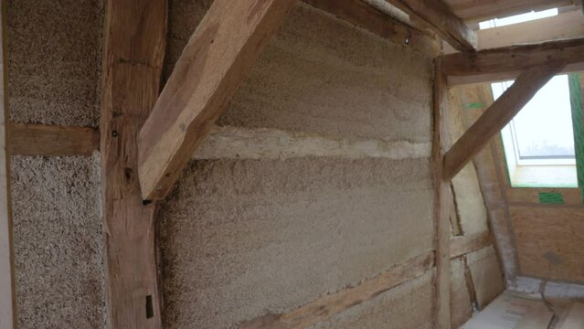 Diagonal zoom out of hempcrete wall in timber frame inside an attic during construction