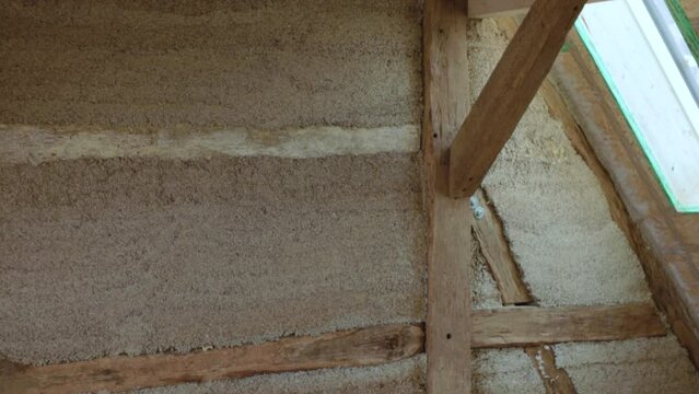 Transition sideways revealing a hempcrete wall in a timber frame inside a construction site