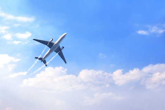 Horizontal nature background with aircraft and Jet trailing smoke in the sky. Airplane and condensation trail. Foggy trail jet and plane in blue sky with white clouds. Traveling the world concept
