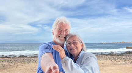 Portrait of senior caucasian couple together in outdoors at the sea beach enjoying vacation and retirement