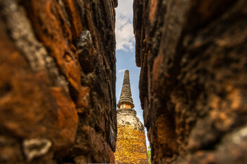 Narrow.  Ayutthaya temple framed by a narrow gap in red brick walls.