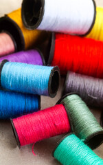 collection of colorful sewing thread on grey, with copy space

