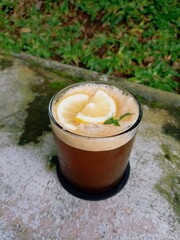 Americano iced coffee with sliced lemon and mint leaves