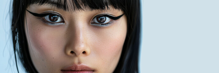 Portrait of a young Asian woman with black winged eyeliner and ample copyspace