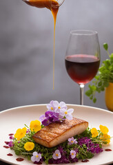 Grilled fish fillet with salad and red wine on gray background