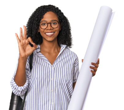 Young African American architect with blueprint cheerful and confident showing ok gesture.