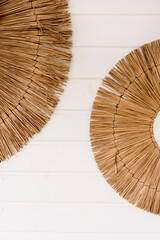 Decorative boho style straw plates on white wall