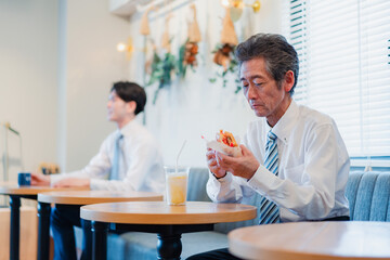 ハンバーガーショップでランチを食べるビジネスマン