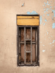 Homemade wooden window installed on the wall of an old house
