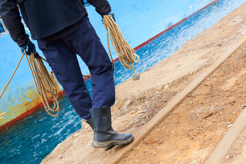 Partial view of the docker with ropes in his hands in the Port of Bilbao