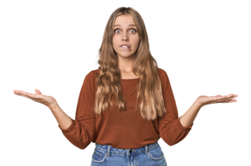 Studio portrait of a blonde Caucasian woman confused and doubtful shrugging shoulders to hold a copy space.