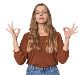 Studio portrait of a blonde Caucasian woman relaxes after hard working day, she is performing yoga.