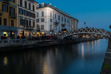 Naklejka premium Milan, Italy 03-07-2024 The navigli are a system of interconnected canals in and around Milan and now known for its quirky charm and lively nightlife scene with bars and restaurants during sunset