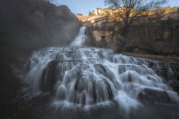 First hours of the day at the Orbaneja del Castillo waterfall, Burgos, a winter day with the...