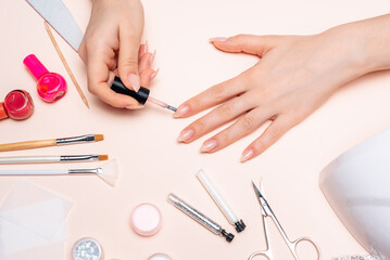 Obraz na płótnie Canvas Manicure. A girl paints her nails. Hands close up