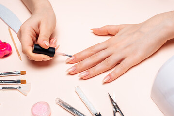 Obraz na płótnie Canvas Manicure. A girl paints her nails. Hands close up