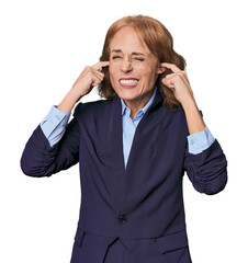 Mid-aged Caucasian businesswoman in blazer covering ears with hands.