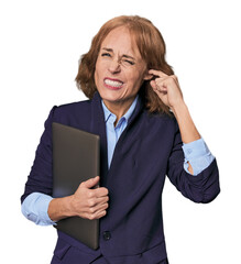 Mid-aged Caucasian with laptop in studio covering ears with hands.