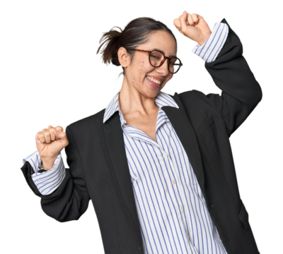 Confident young Caucasian businesswoman on studio background celebrating a special day, jumps and raise arms with energy.