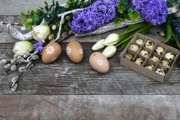 Blumen und Ostereier auf einem Holz Hintergrund mit Platz für Text.