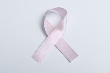 Pojedyncza różowa wstążka na szarym tle, symbol walki z rakiem piersi - obrazy, fototapety, plakaty