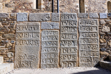 Gravures de sépultures dans la pierre devant l'église de Llivia
