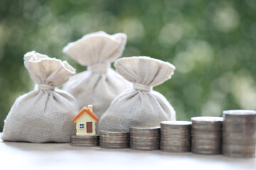 Finance, Model house with money bag on natural green background,Business investment and Save money for prepare in future concept