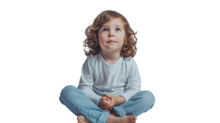 A young girl sitting on the floor with her legs crossed in a whimsical and contemplative pose