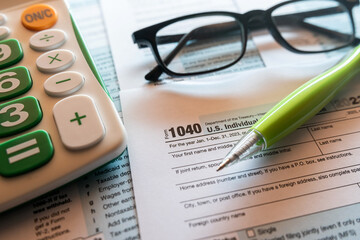 1040 TAX form blank on a calculator.  Individual Income Tax Return