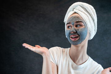 young beautiful woman wear white towel doing beauty wellness treatment with black clay facial mask