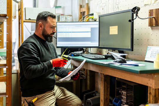 Dispatcher scanning bar codes near computer at desk