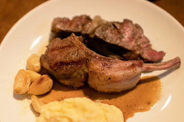 Grilled lamb ribs with mashed potato and grilled garlic.