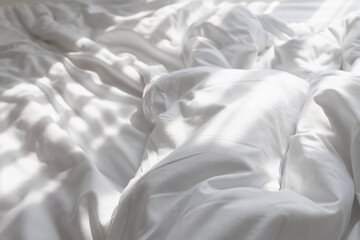 Unmade bed with shades of sunlight through the curtain in morning. - obrazy, fototapety, plakaty