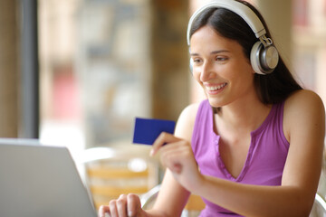 Happy woman with headphone buying online - 761245684