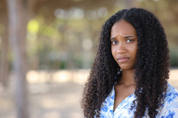 Disappointed black woman looking at camera in a park - 761245693
