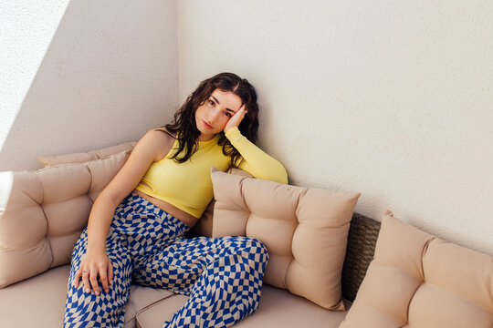Young woman sitting on sofa at home