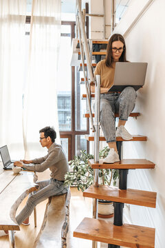 IT technicians coding through laptops at creative startup office
