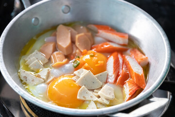 Eggs are cooked in a little pan served in, and topped with sweet sausage and pork stick. Pan Eggs or 