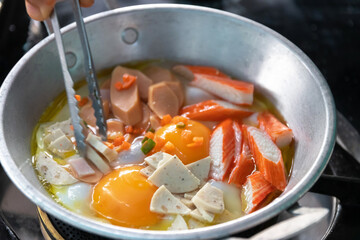 Eggs are cooked in a little pan served in, and topped with sweet sausage and pork stick. Pan Eggs or 