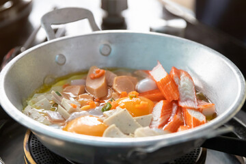 Eggs are cooked in a little pan served in, and topped with sweet sausage and pork stick. Pan Eggs or 