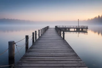 Tuinposter Wooden pier at a misty dawn in a quiet sea © Galina
