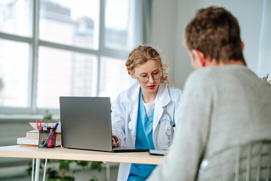 Doctor having discussion with patient at desk in office