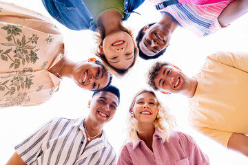 Multiethnic group of young friends with colorful clothing bonding outdoors in the city, concepts about youth and lifestyle - Barcelona, Spain