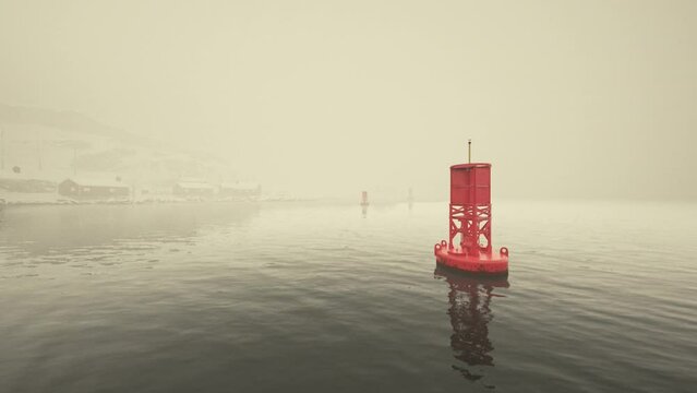 A red metal buoy floats atop the cold waters of the Norwegian sea.