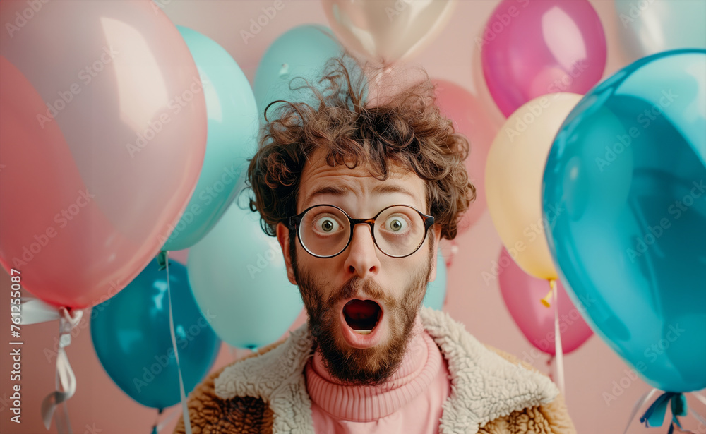 Poster A man with glasses and a beard is standing in front of a bunch of balloons. He is looking surprised. The balloons in various colors and sizes. Surprised expression of incredible news, surrounded