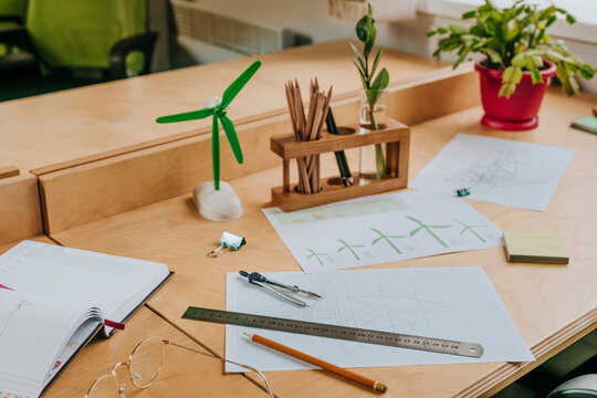Desk with blueprint of wind turbine and model in office